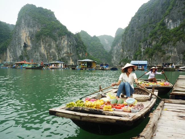 Woman selling fruits from a boat in Halong Bay Village, Vietnam